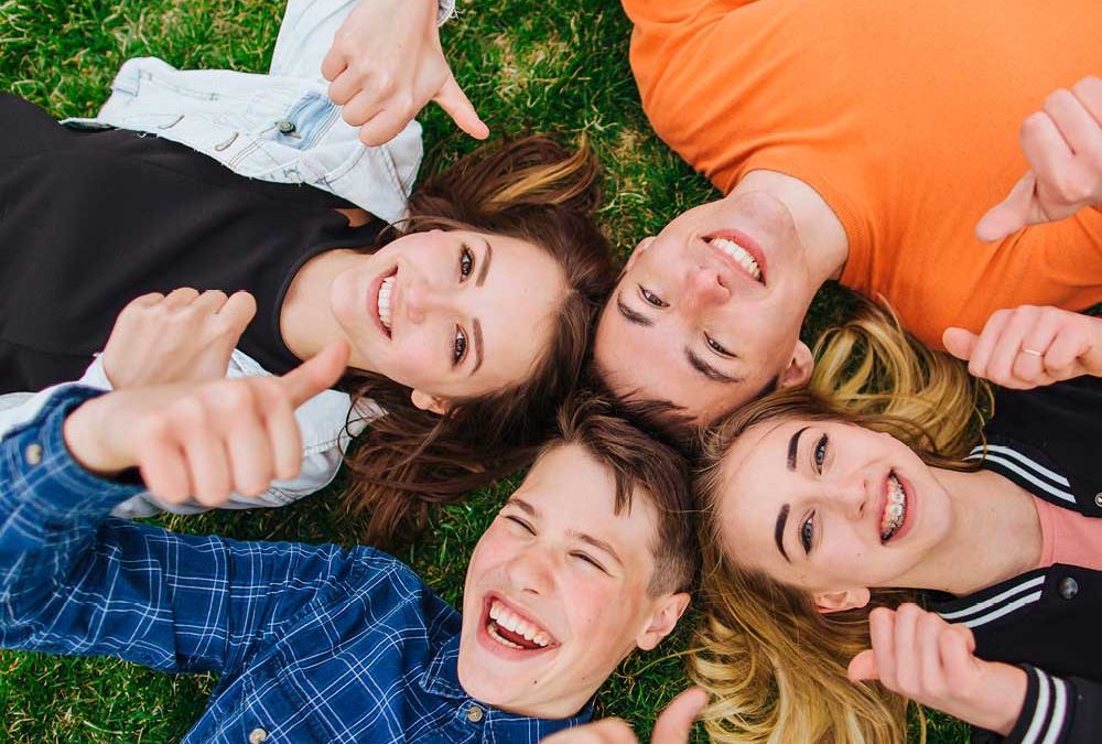 Vier junge Menschen liegend auf einer Wiese mit Daumen nach oben für die Beilage „Ausbildungsperspektiven“ von Oberpfalz Medien.