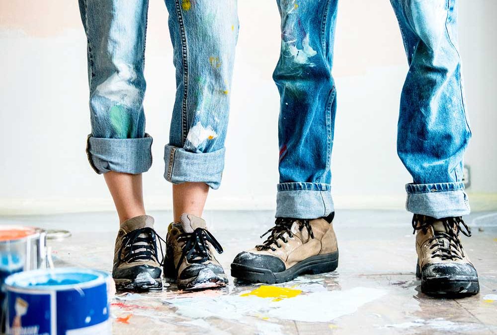 Vier mit Farbe bespritzte Beine in Jeans für die Beilage „Bauen, sanieren, renovieren“ von Oberpfalz Medien.