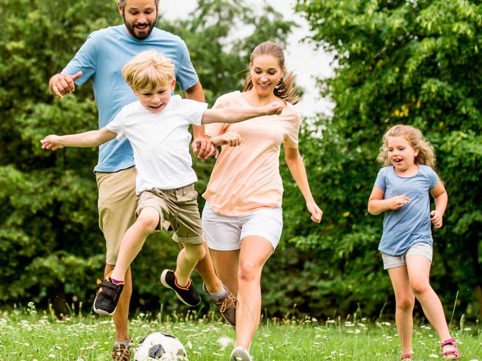 Auf einer Wiese Fußball spielende Familie für die Beilage „Ferien in der Region“ von Oberpfalz Medien.