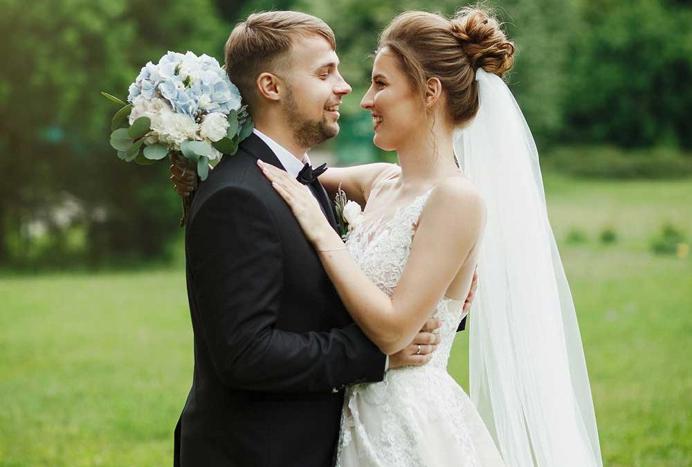 Brautpaar auf Wiese vor Bäumen für die Beilag „Traumhochzeit“ von Oberpfalz Medien.